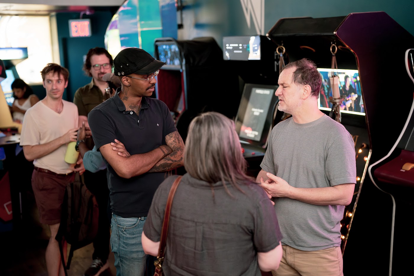 Event organizers talking together beside arcade games
